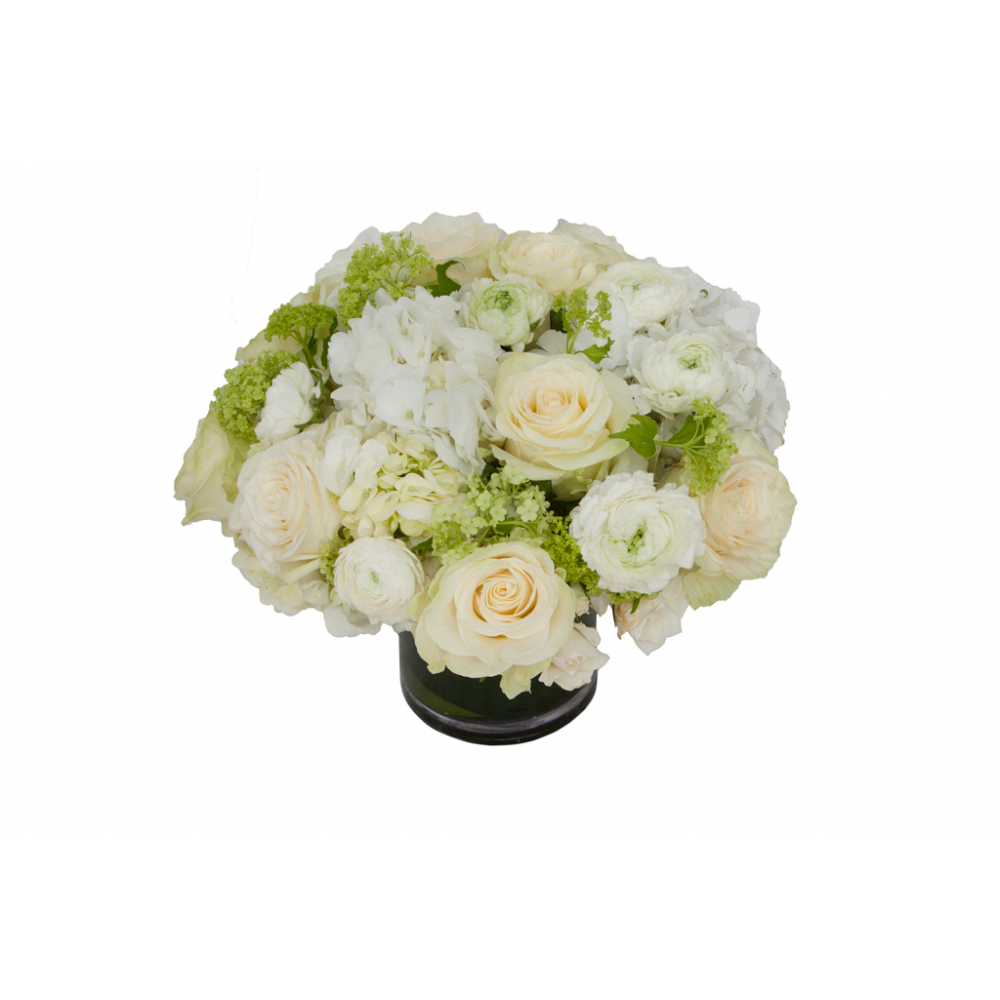 Flower arrangement in a low, round, clear glass vase, white hydrangeas, green viburnums,  white roses and white ranunculus