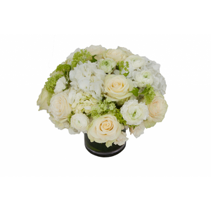 Flower arrangement in a low, round, clear glass vase, white hydrangeas, green viburnums,  white roses and white ranunculus