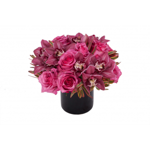 Flower arrangement in a low, round, black, ceramic vase, pink roses and pink cymbidium orchids