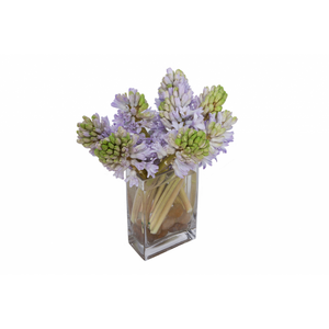 Flower arrangement in a low, rectangle, clear vase, lavender hyacinths