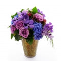 Flower arrangement in a medium tall, zinc bucket, blue hydrangeas, purple roses, purple vanda orchids and seedeed ivy